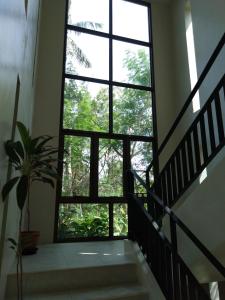 eine Treppe in einem Haus mit einem großen Fenster in der Unterkunft C-VIEW BOUTIQUE in Rawai Beach