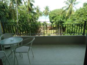 een balkon met een tafel en stoelen en uitzicht op de oceaan bij C-VIEW BOUTIQUE in Rawai Beach