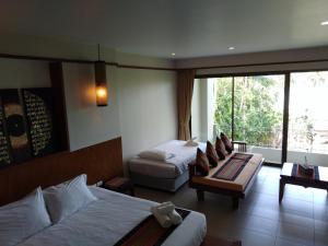 Habitación de hotel con 2 camas y sofá en C-VIEW BOUTIQUE, en Rawai Beach