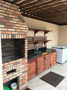 a kitchen with a brick wall and a sink at AP 05 com Jacuzzi - Sol e Mar Residence Be Summer in Flecheiras