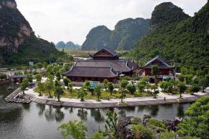a large building in the middle of a river at Lam Dat Hotel in Ninh Binh