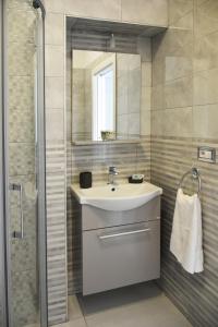 a bathroom with a sink and a mirror and a shower at Costantino Suites in Sorrento