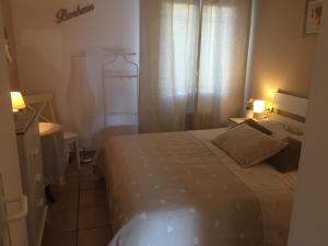 a small bedroom with a bed and a window at Clos des Templiers in Saint-Rémy-de-Provence