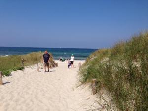 ツィングストにあるKomfortapartment Zingster-Meerblickの海辺の砂浜を歩く男