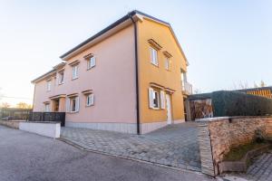 a yellow and white house with a brick driveway at Apartment Solinar in Soline