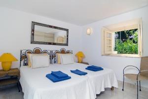 a bedroom with a bed with blue pillows on it at Vila Monte Luz in Ferragudo