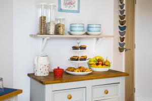 a shelf with three bowls of fruit on a counter at An Cois Na Mara Bed & Breakfast in Laide +15 photos