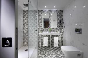 a white toilet sitting next to a sink in a bathroom at Eurostars Porto Douro in Porto