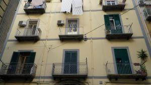a tall building with balconies and windows with clothes hanging from them at Donna Vicenza Bed & Breakfast in Naples