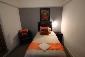
a bedroom with a bed, desk, and nightstand at Donkin Country House in Beaufort West
