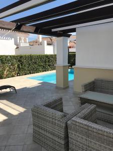 a patio with wicker chairs and a pool at Villa Pagel - A Murcia Holiday Rentals Property in Roldán