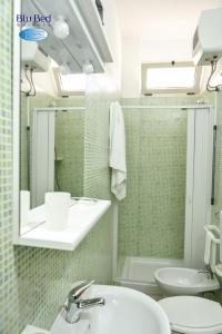 a bathroom with a sink and a toilet and a mirror at Blu Bed Salento in Torre Lapillo