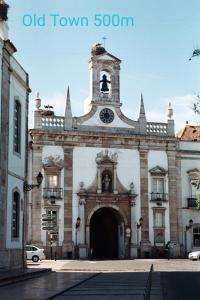 an old town building with a clock tower on it at Reis Turismo 2 in Faro +13 photos