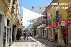 a street with people walking down a street with buildings at Reis Turismo 2 in Faro
