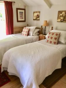 two beds sitting next to each other in a bedroom at Culloden Farmhouse in Camelford