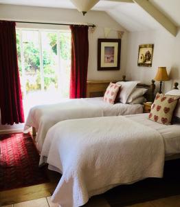 a bedroom with two beds and a window at Culloden Farmhouse in Camelford