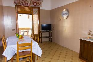 una sala da pranzo con tavolo e TV di Casa Caramella ad Avola