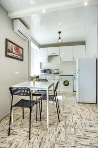 a kitchen with a table and chairs and a refrigerator at Apartment Perekopska st. in Kherson