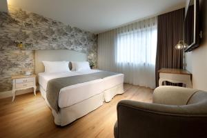 a hotel room with a bed and a chair at Eurostars Porto Douro in Porto