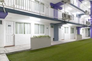 a large building with a green lawn in front of it at Hotel25 in Monterrey