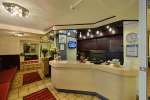 a restaurant with a counter and a clock on the wall at Bellevue Hotel in Düsseldorf