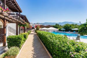 a walkway next to a resort with a swimming pool at Citrus Tree Gardens in Kyrenia