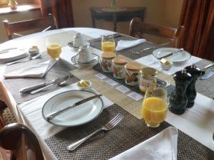 einen Tisch mit Teller und Gläsern Orangensaft in der Unterkunft Manor House Farm in Rufford