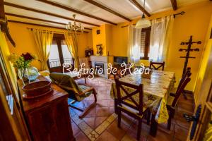 ein Esszimmer mit einem Tisch und eine Küche mit gelben Wänden in der Unterkunft Casa Rural Refugio de Heda in San Bartolomé de Tormes