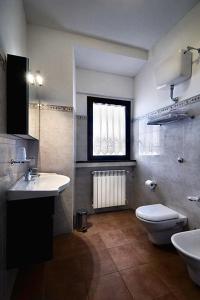 een badkamer met een wastafel, een toilet en een raam bij Il Poggio Dei Pettirossi in Pettorano sul Gizio