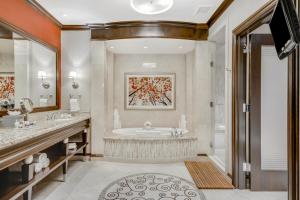 
a bath room with a sink, mirror and a bath tub at Harrah's Resort Atlantic City Hotel & Casino in Atlantic City
