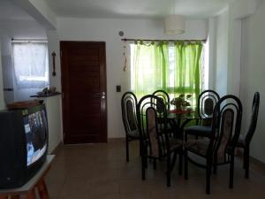 a dining room with a table and chairs and a television at Maraja1 in Mar de Ajó