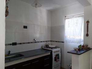 a kitchen with a stove and a sink at Maraja1 in Mar de Ajó