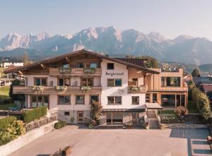 a large white building with mountains in the background at Bio Hotel Bergkristall in Schladming