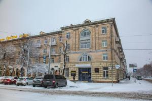 um grande edifício de tijolos com carros estacionados em frente em Optima Cherkasy Hotel em Cherkasy