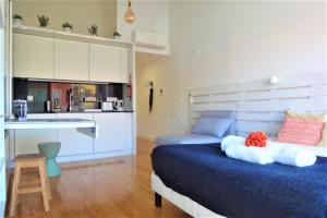 a bedroom with a blue bed and a kitchen at Porto Sunny Terrace Almada in Porto