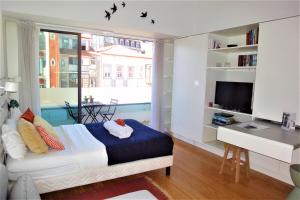 Schlafzimmer mit einem Bett, einem Schreibtisch und einem Fenster in der Unterkunft Porto Sunny Terrace Almada in Porto