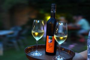 a bottle of wine and two glasses on a table at Gästezimmer Poys in Auersthal