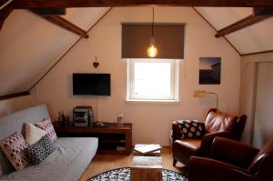 a living room with a couch and a chair at het Bakkershuisje in Colijnsplaat