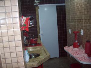 a small bathroom with a sink and a mirror at KITINETI A 200 M DA PRAIA DO FORTE -PRÉDIO TRÊS RIOS in Cabo Frio