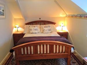 a bedroom with a large wooden bed with two lamps at Culloden Farmhouse in Camelford