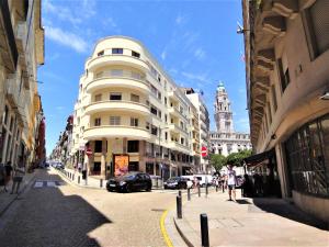a large white building on a city street with buildings at Porto Sunny Terrace Almada in Porto