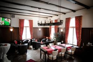 ein Esszimmer mit roten Tischen und Stühlen in der Unterkunft Heerens Hotel in Emden