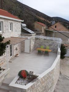 un patio con tavolo e sedie su un muro di pietra di Kuća za odmor Slavija a Orebić (Sabbioncello)