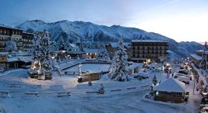 オロンにあるLa Grange d'Aur - Place d'Auronの山々を背景に雪に覆われた町