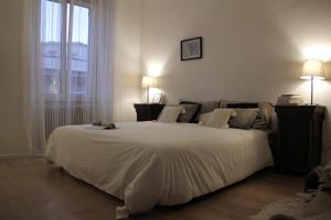 a bedroom with a large white bed with two lamps at Urbanflat Roma in Rome