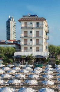 a large hotel with a lot of umbrellas in front of it at Hotel Delaville Frontemare in Lido di Jesolo
