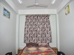 ein Schlafzimmer mit einem Bett und einem Vorhang in der Unterkunft The Lotus Home in Port Blair