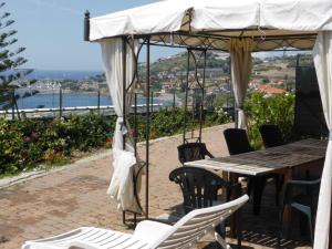 een tafel en stoelen onder een luifel met een tafel en stoelen bij Villa del Mare Ligure in Santo Stefano al Mare