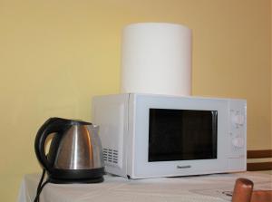 a microwave sitting on top of a table with a kettle at Hotel Eurorooms in Rome