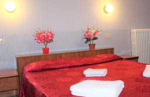 a bedroom with a red bed with two towels on it at Hotel Eurorooms in Rome
